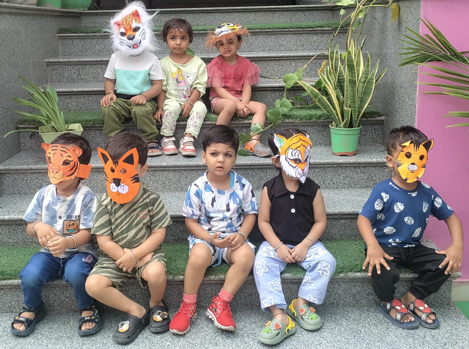 Children in tiger masks sitting on the school steps